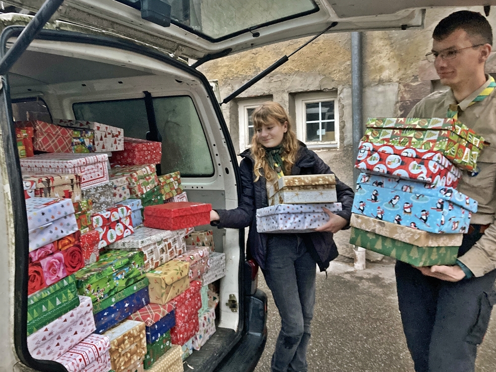 Zwei Pfadfinder verladen gepackte Geschenke Zwei Pfadfinder verladen gepackte Geschenke